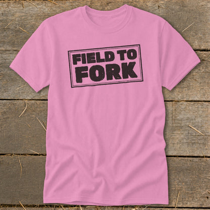 A pink short-sleeve t-shirt with a black distressed box design reading Field to Fork centered on the chest.