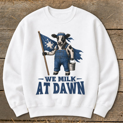 Cow in overalls holding flag with milk splash, "We Milk At Dawn" text.