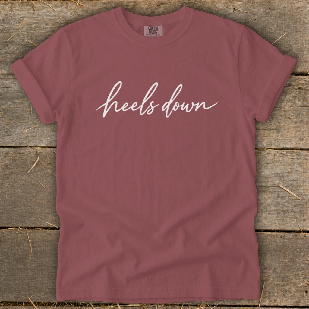 Rose comfort colors t-shirt with white "heels down" script text.