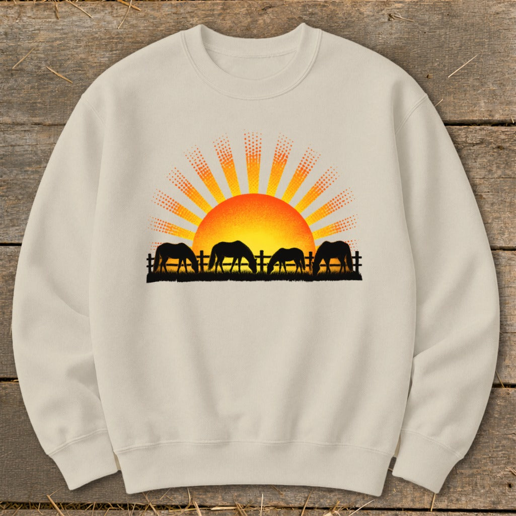 Crewneck sweatshirt with horses and sunrise graphic across chest.