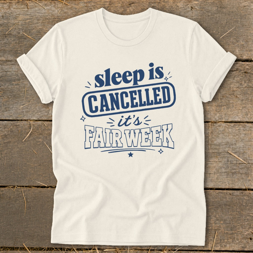Cream t-shirt with dark blue text: "sleep is CANCELLED it's FAIR WEEK".
