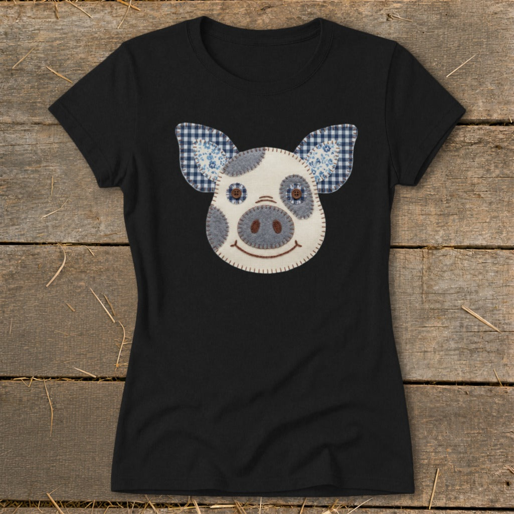 Black t-shirt with a patchwork pig face graphic and blue gingham ears.