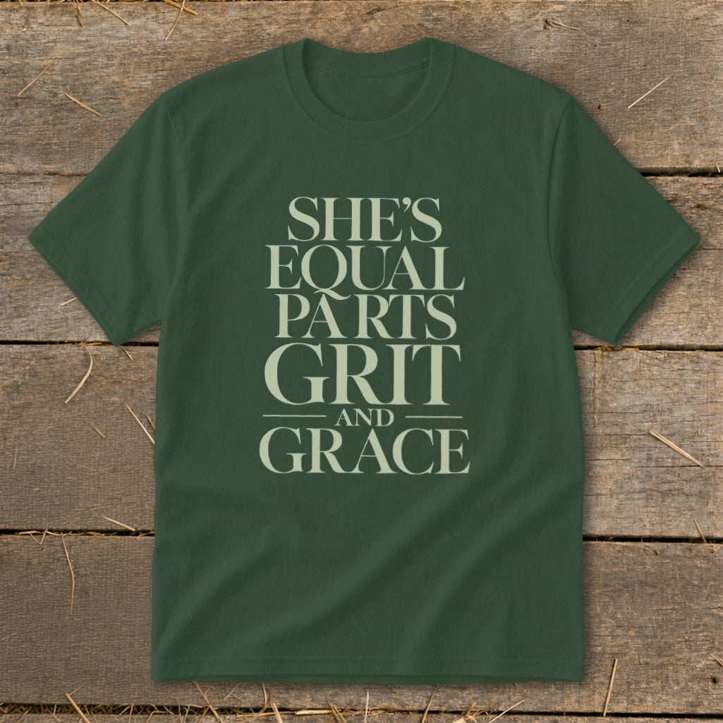 Green t-shirt with text "SHE'S EQUAL PARTS GRIT AND GRACE" in cream.