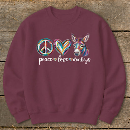 Burgundy sweatshirt with "peace love donkeys" and colorful graphics of a peace sign, heart, and donkey.