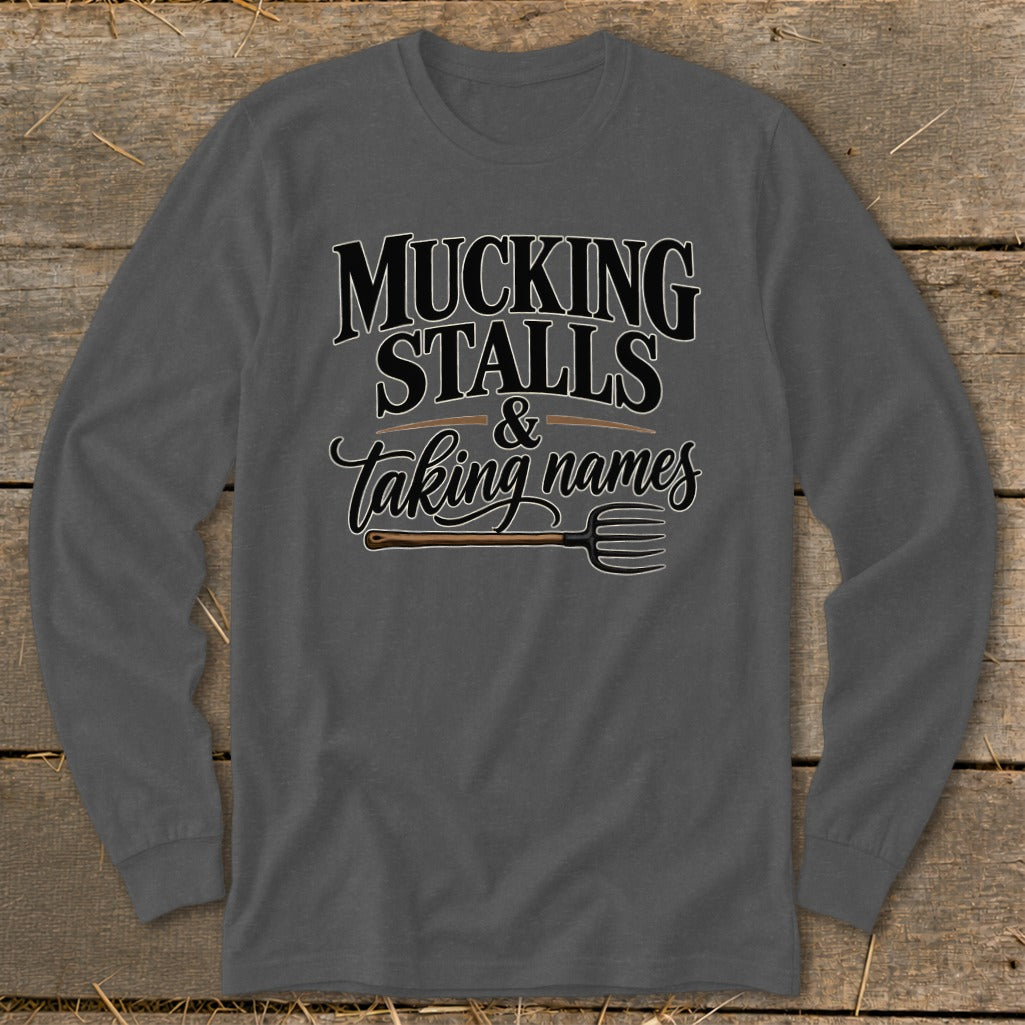 Long sleeve shirt with text "MUCKING STALLS & Taking names" and a pitchfork.