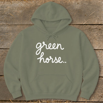 Green hoodie with white "green horse.." text on a wooden background.