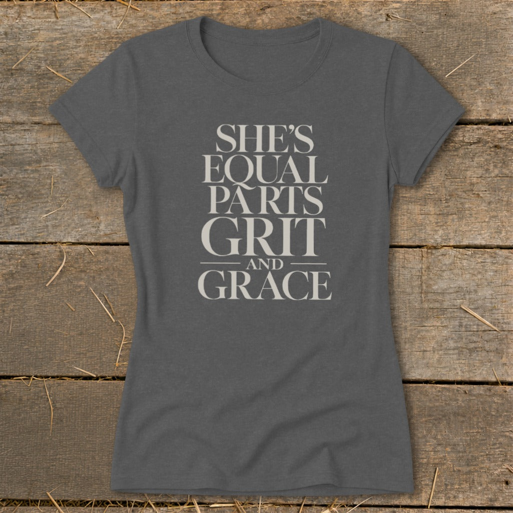 Dark grey t-shirt with "SHE'S EQUAL PARTS GRIT AND GRACE" printed in off-white text.