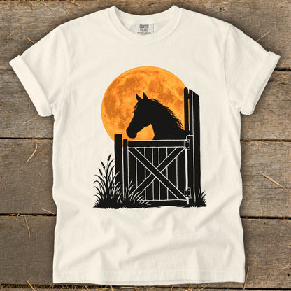 Off-white crewneck t-shirt featuring a black silhouette graphic of a horse looking over a stable door against an orange full moon.