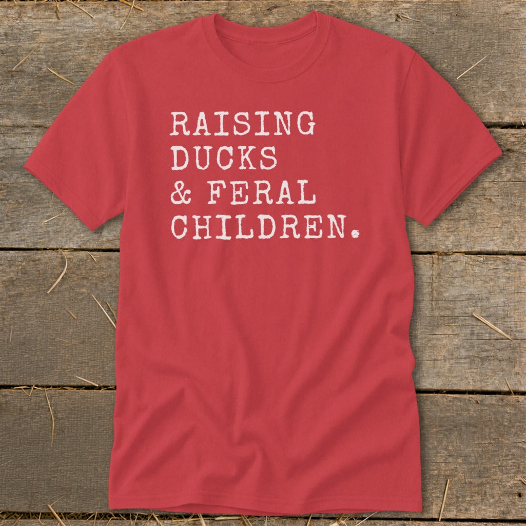 Red t-shirt with white text reading "RAISING DUCKS & FERAL CHILDREN."