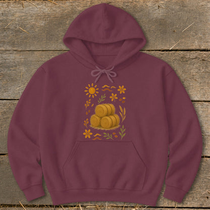 Maroon hoodie with a fall-themed graphic of hay bales, sun, and flowers.
