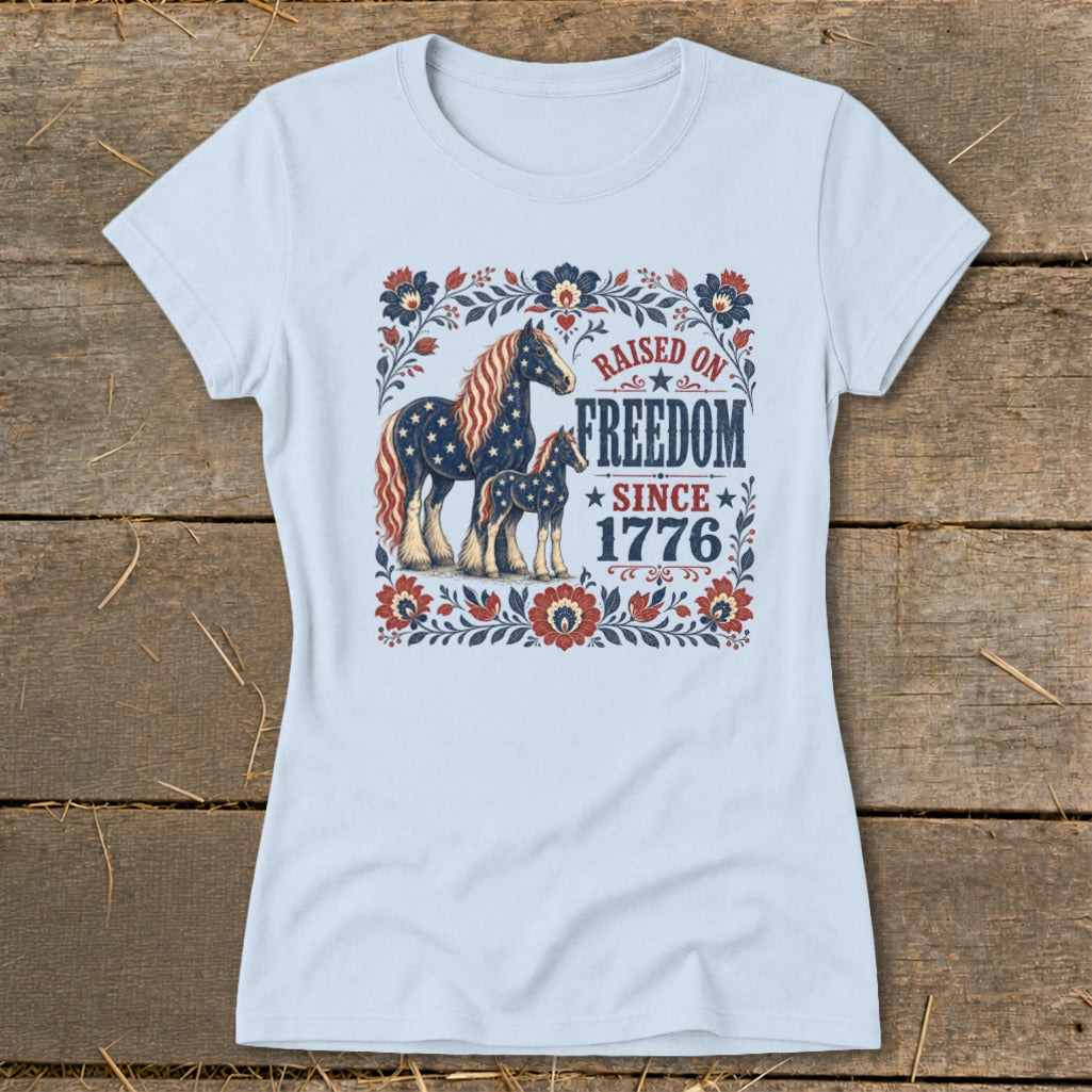 Light blue t-shirt with horses and "Raised on Freedom Since 1776" text.