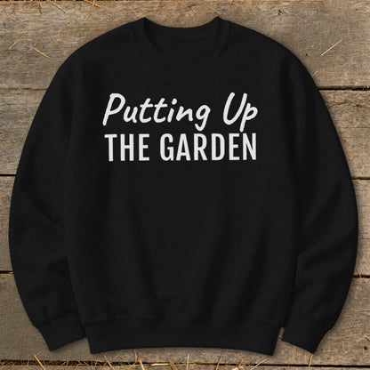 Black sweatshirt with white text reading "Putting Up THE GARDEN".