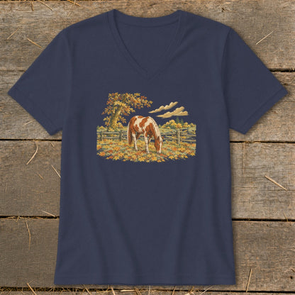 Navy t-shirt with a painting of a brown and white horse in a fall pasture.
