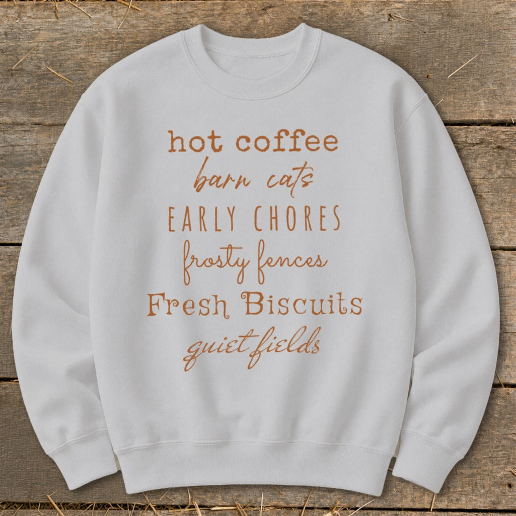 White sweatshirt with "hot coffee, barn cats, early chores, frosty fences, fresh biscuits, quiet fields" text.
