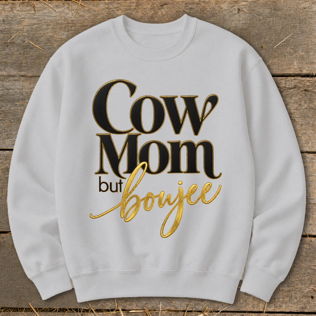 White sweatshirt with black and gold text reading "Cow Mom but boujee".