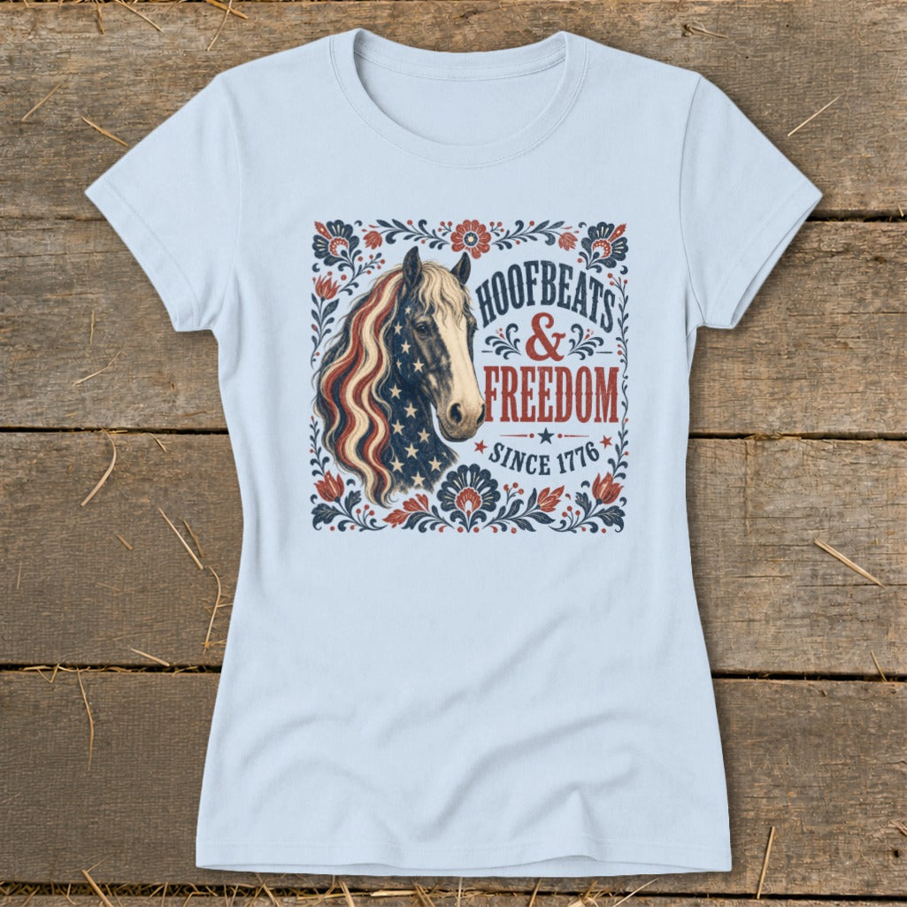 Light blue t-shirt with a horse wearing an American flag mane and "Hoofbeats & Freedom Since 1776" text.