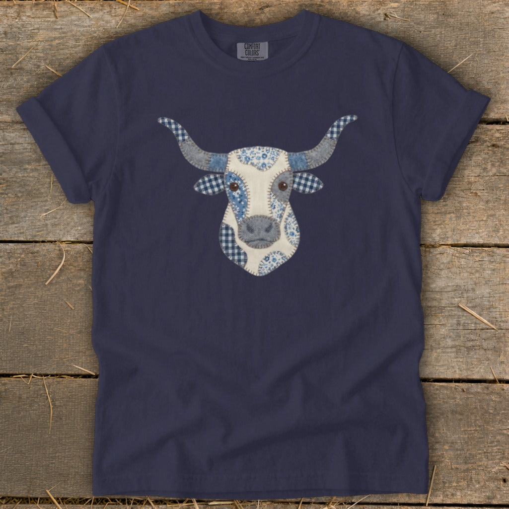 Navy t-shirt with a blue and white patchwork cow face graphic.
