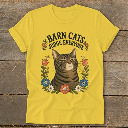 Yellow t-shirt with a tabby cat illustration and the text "BARN CATS JUDGE EVERYONE".