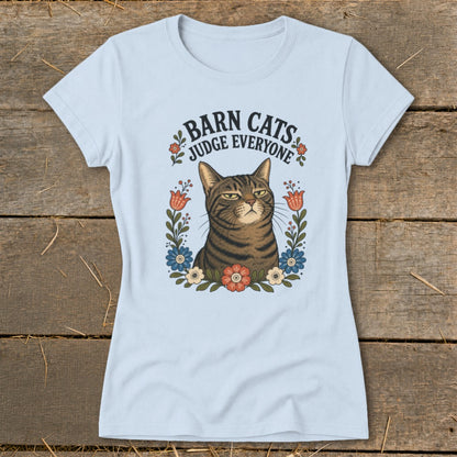 Light blue t-shirt with a grumpy tabby cat surrounded by flowers and text "Barn Cats Judge Everyone".