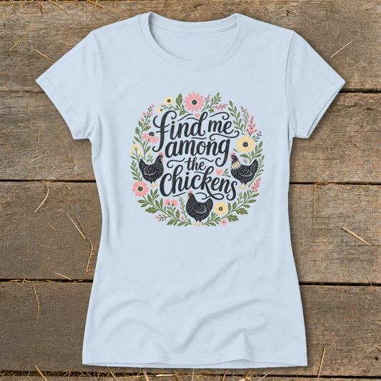 Light blue t-shirt with a floral wreath design and the text "Find me among the chickens".