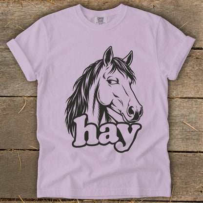 Black horse head graphic with the word "hay" on a light purple t-shirt.