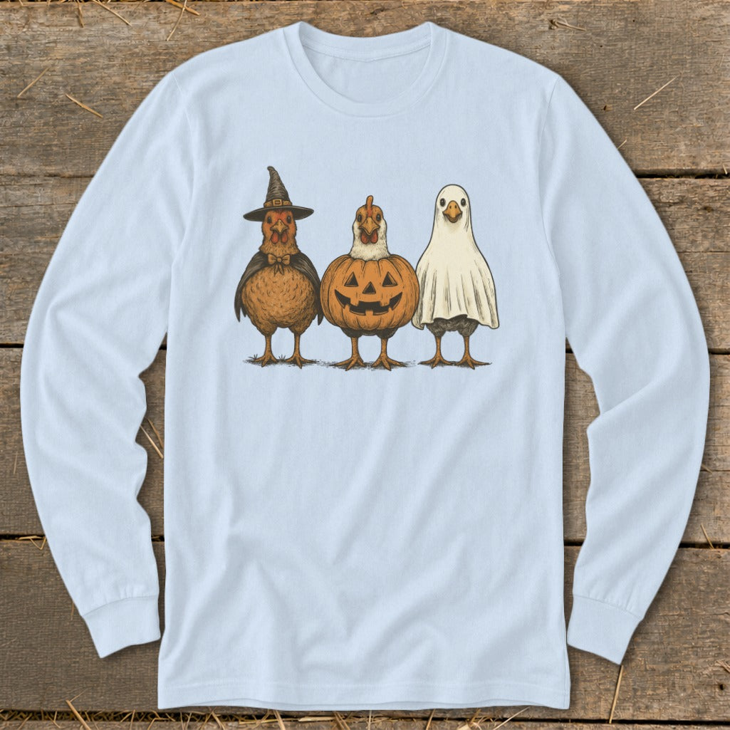 Three chickens dressed as a witch, pumpkin, and ghost on a light blue long-sleeve shirt.