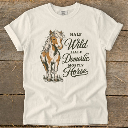 White t-shirt with a brown and white horse illustration and text "Half Wild, Half Domestic, Mostly Horse".