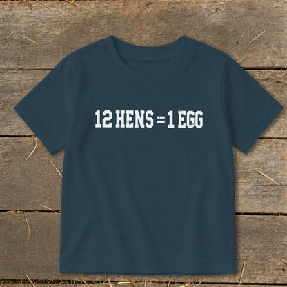 A dark blue short-sleeved child's t-shirt printed with white text reading 12 HENS = 1 EGG.