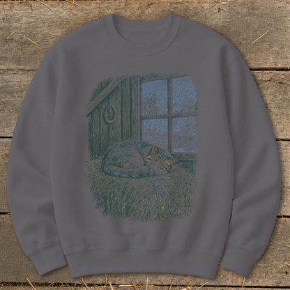 Tabby cat sleeping on straw by a window looking out at snow.