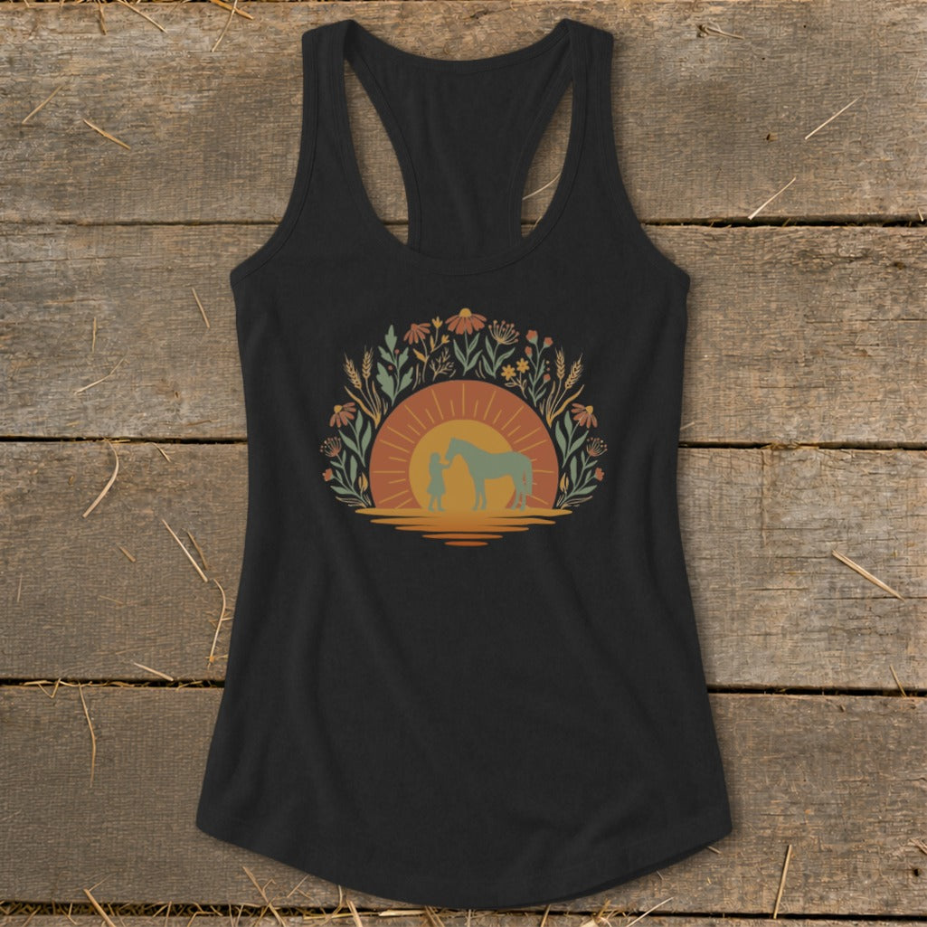 Black tank top with sunset, wildflowers, girl, and horse graphic.