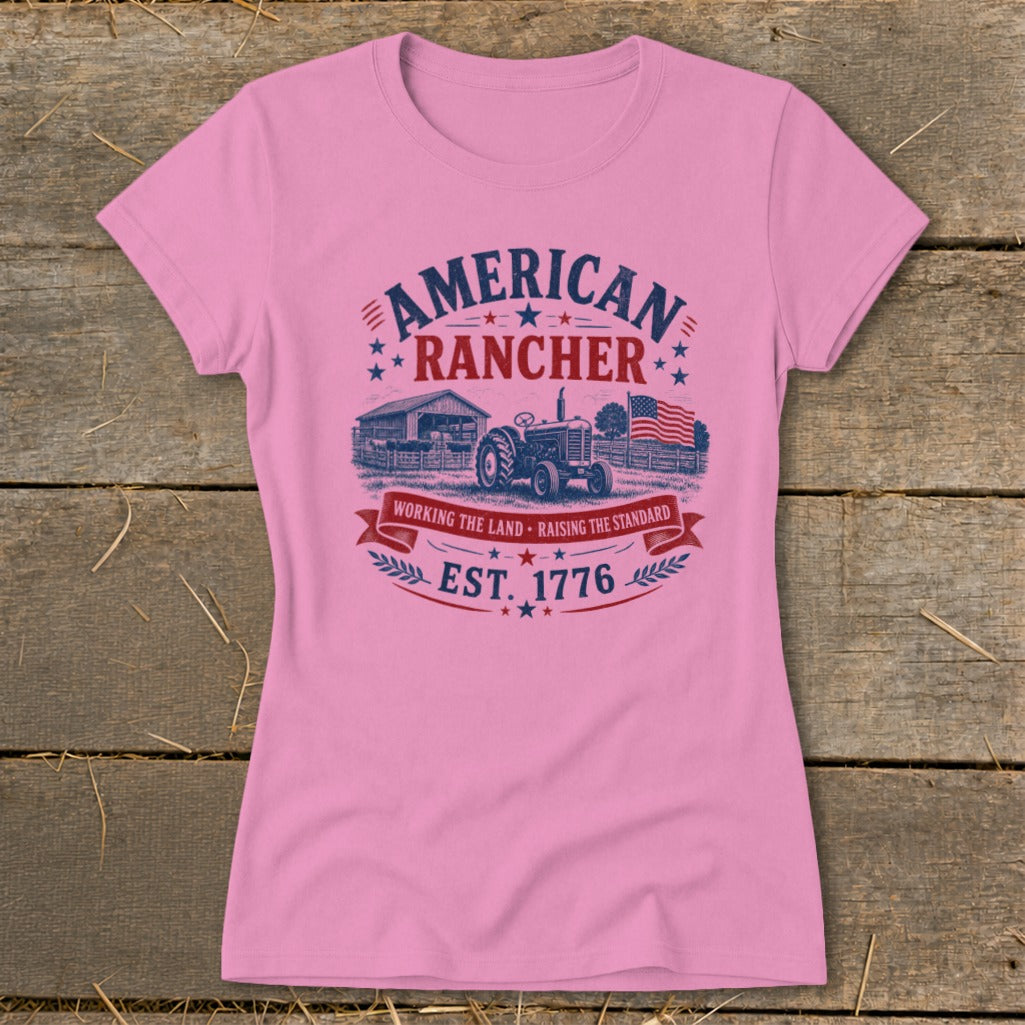 Pink t-shirt with "American Rancher" graphic, tractor, barn, American flag, and "Est. 1776."