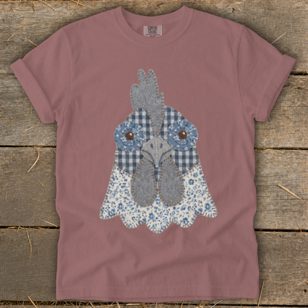 Rose t-shirt with a fabric applique of a chicken's face with blue gingham and floral patterns.
