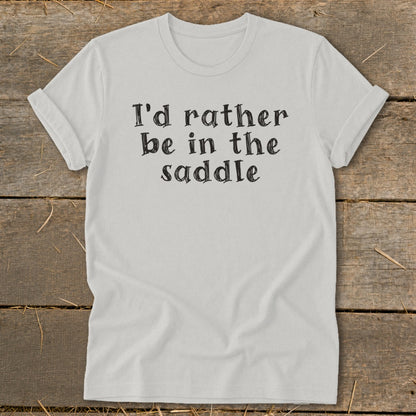 Light grey t-shirt with black text "I'd rather be in the saddle."