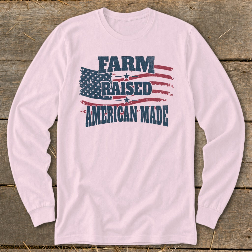 Pink long-sleeve shirt with distressed "FARM RAISED AMERICAN MADE" text over an American flag.