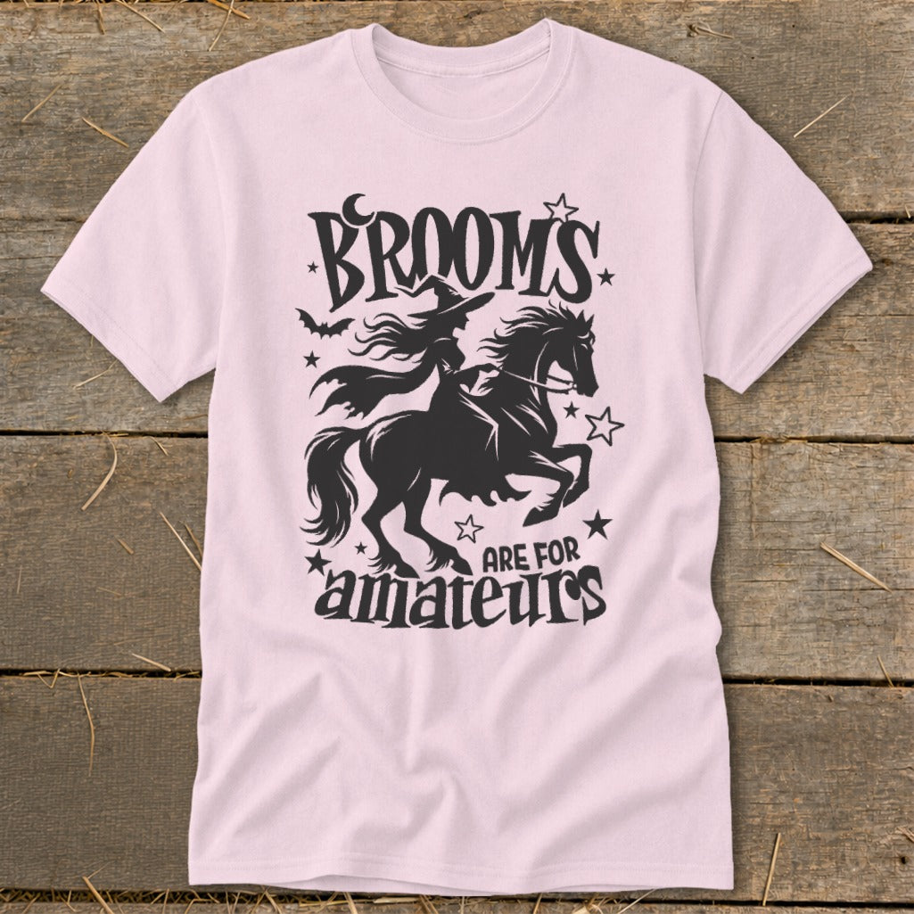 Pink t-shirt with witch on horse graphic and text "Brooms are for amateurs".