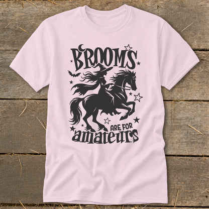 Pink t-shirt with witch on horse graphic and text "Brooms are for amateurs".
