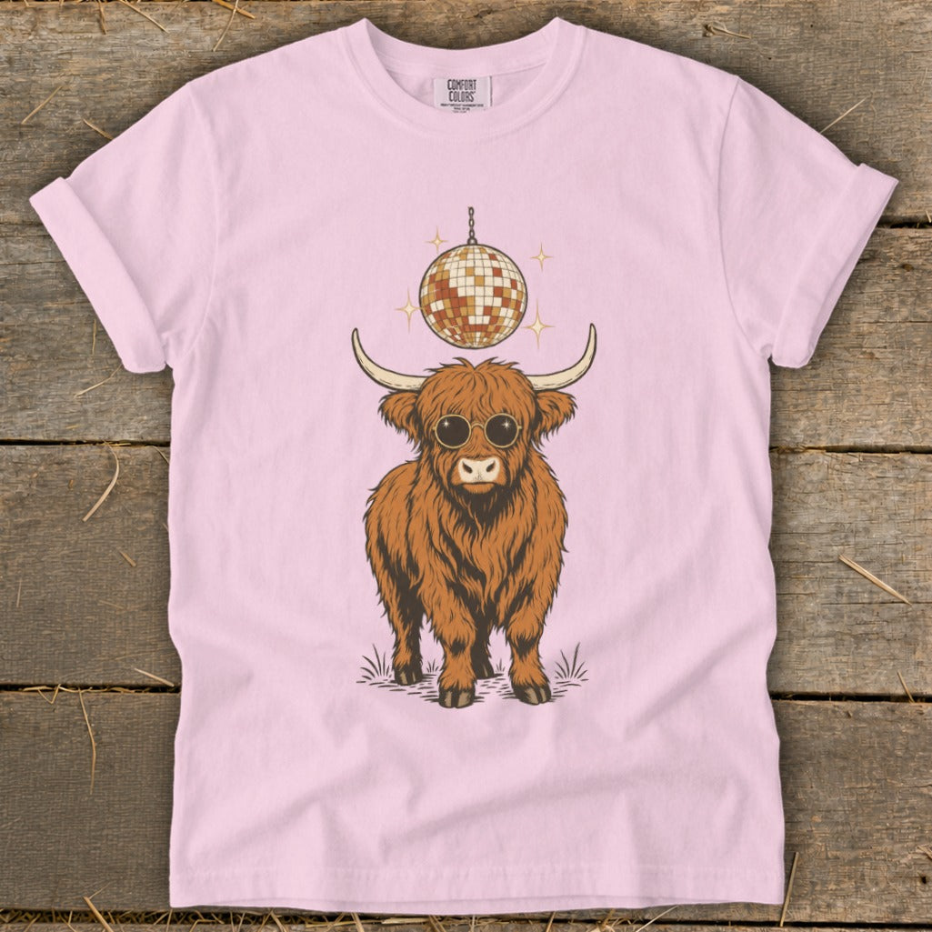 Highland cow wearing sunglasses under a disco ball on a pink t-shirt.