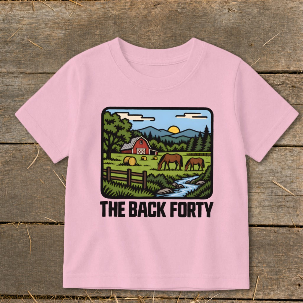 Light pink t-shirt featuring a cartoon farm graphic with horses, a barn, and the text The Back Forty.