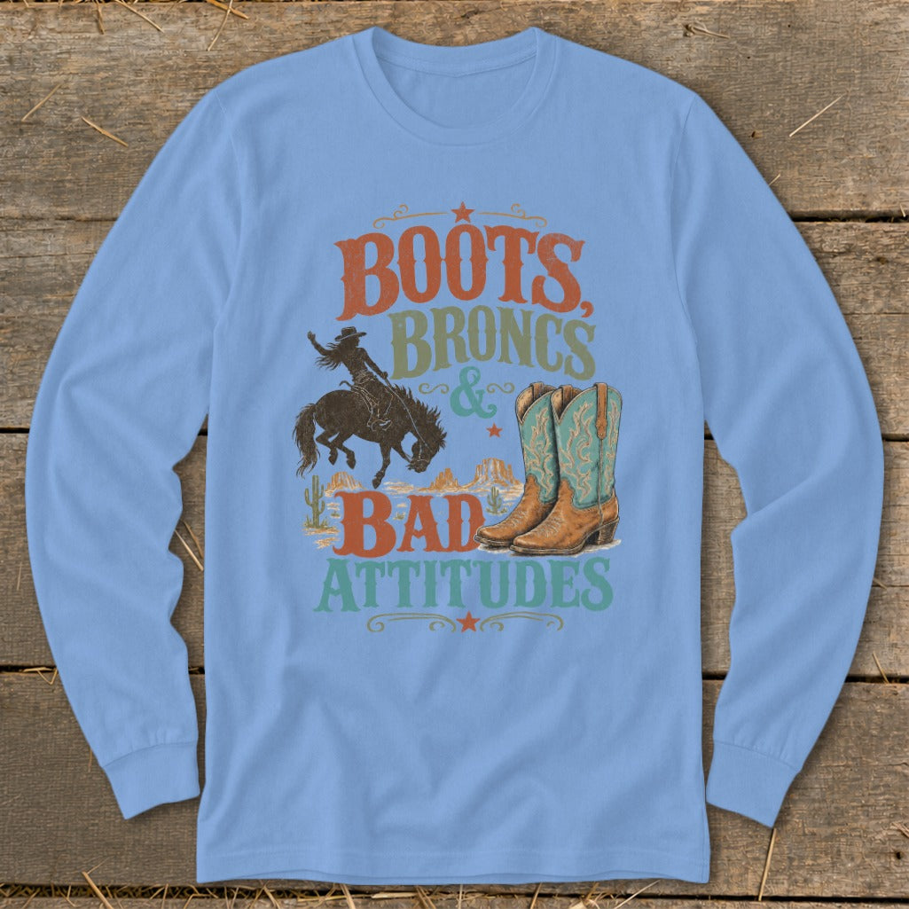 Long sleeve shirt graphic with text "BOOTS, BRONCS & BAD ATTITUDES" and cowboy imagery.