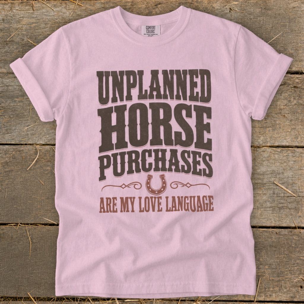 Pink t-shirt with "Unplanned Horse Purchases Are My Love Language" text and horseshoe graphic.