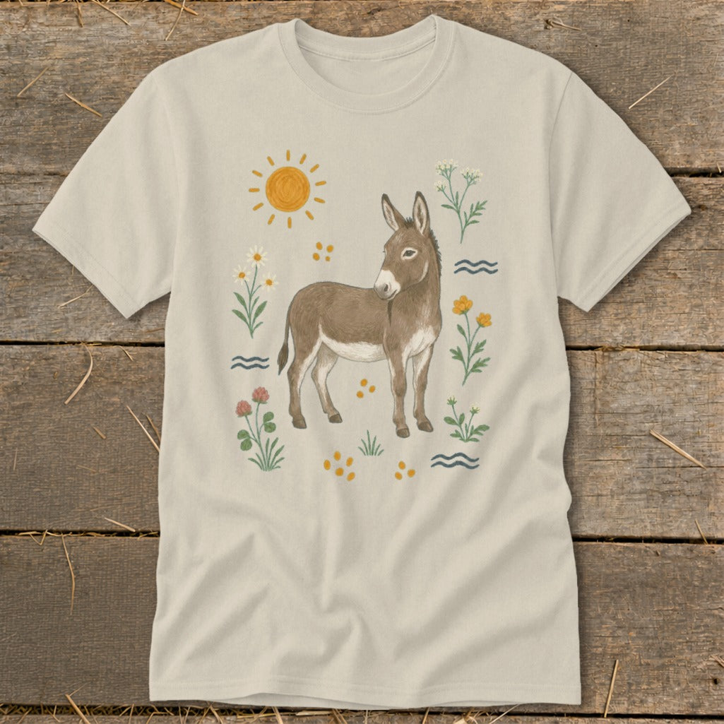 T-shirt with watercolor illustration of a donkey surrounded by flowers, sun, and waves.