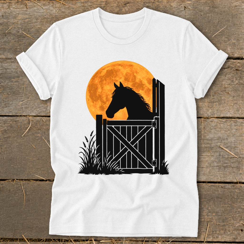 A white t-shirt featuring a graphic of a horse silhouette looking over a stable door against a large orange moon.