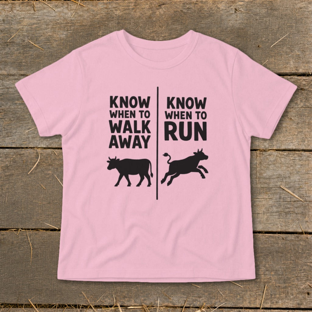 Pink t-shirt with text and black cow silhouettes showing walking and running.