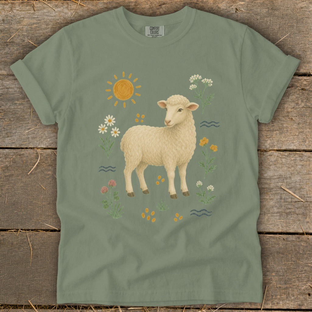Green t-shirt with a cream sheep illustration surrounded by flowers and a sun.