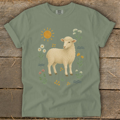 Green t-shirt with a cream sheep illustration surrounded by flowers and a sun.