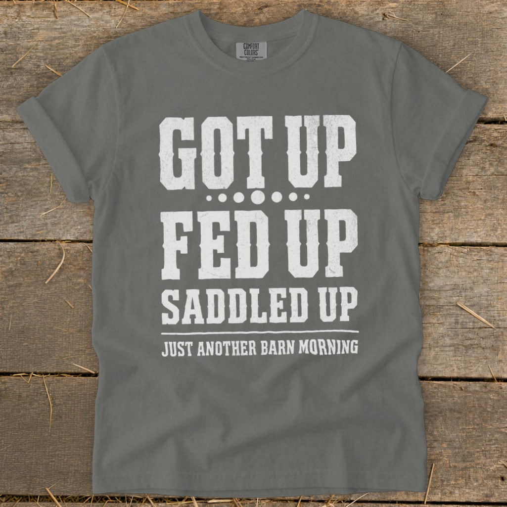 Gray t-shirt with distressed white text reading "GOT UP FED UP SADDLED UP JUST ANOTHER BARN MORNING".