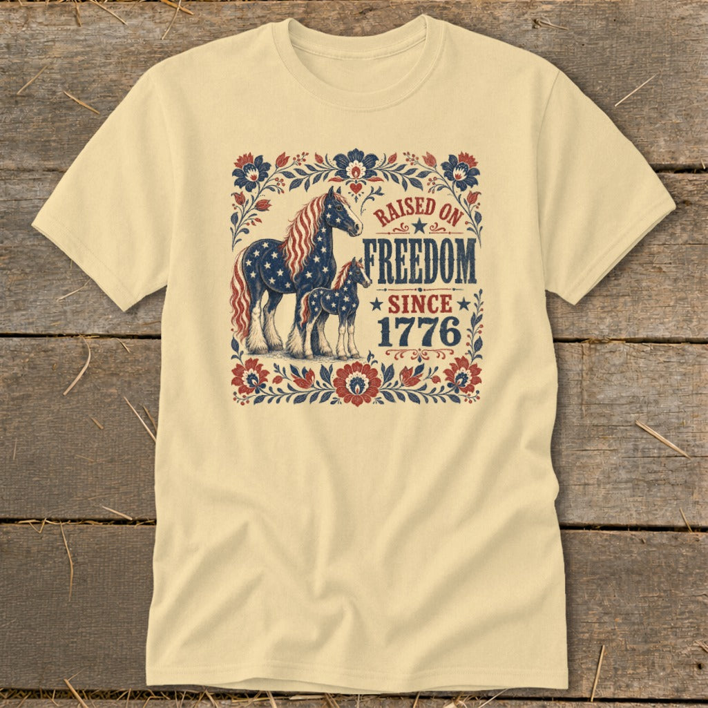Cream t-shirt with horses and "Raised on Freedom Since 1776" text.