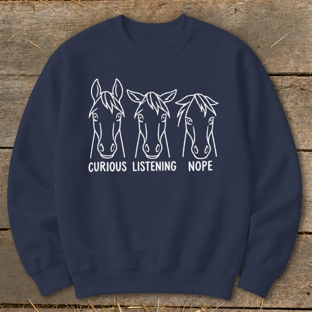 Navy blue crewneck sweatshirt featuring white line art of three horses with the text curious listening nope.