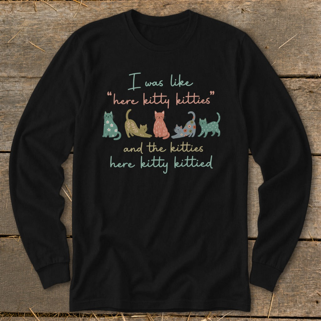 Black long sleeve shirt with text "I was like 'here kitty kitties' and the kitties here kitty kittied" and colorful cartoon cats.