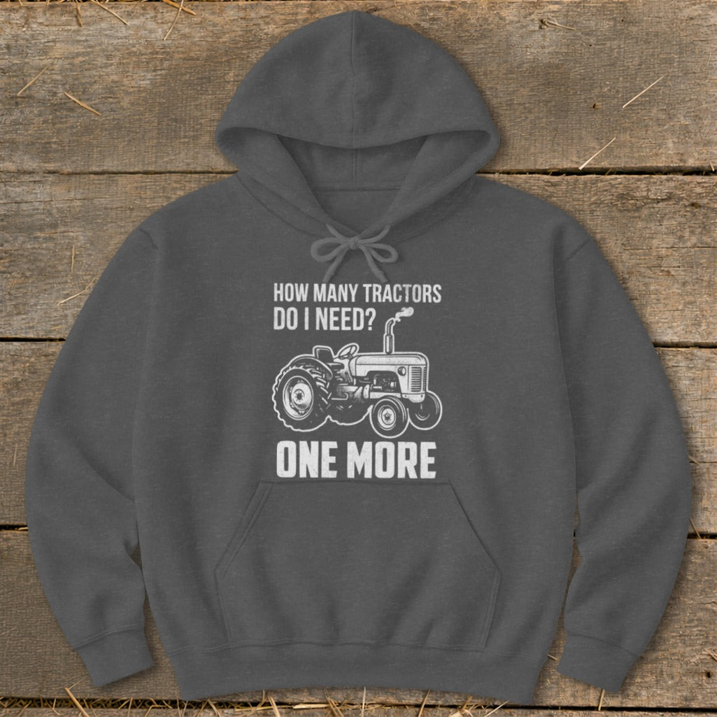 Dark gray hoodie with a graphic of a tractor and text reading "How Many Tractors Do I Need? One More."